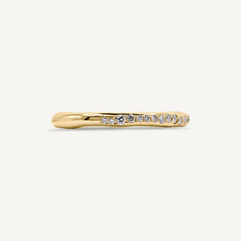 A modern and different eternity ring set with diamonds half way around the band. 100% recycled solid 14ct gold and ethically sourced gemstones. Handmade by South London jeweller Robyn in her studio.