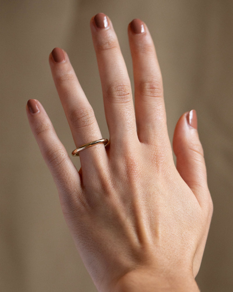 Solid 14ct yellow gold plain wedding ring with a classic timeless design. Inspired by hand-forged rings, this textured minimalistic band has a smooth polished finish. Unisex ring handmade in South London using 100% recycled gold.
