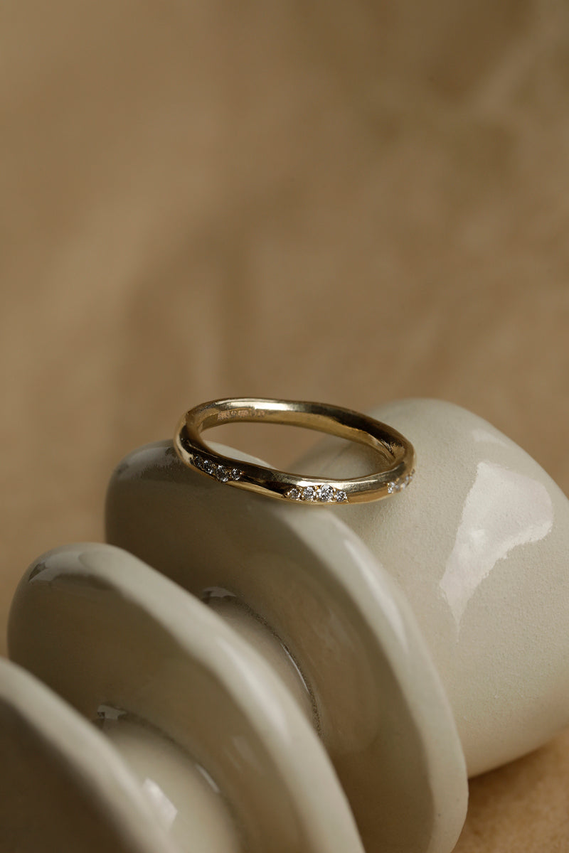 A lightly textured band with clusters of ethically sourced diamonds. Made from 100% recycled solid 14ct gold, this wedding ring is modern yet timeless and is handmade by Robyn in her South London jewellery studio.