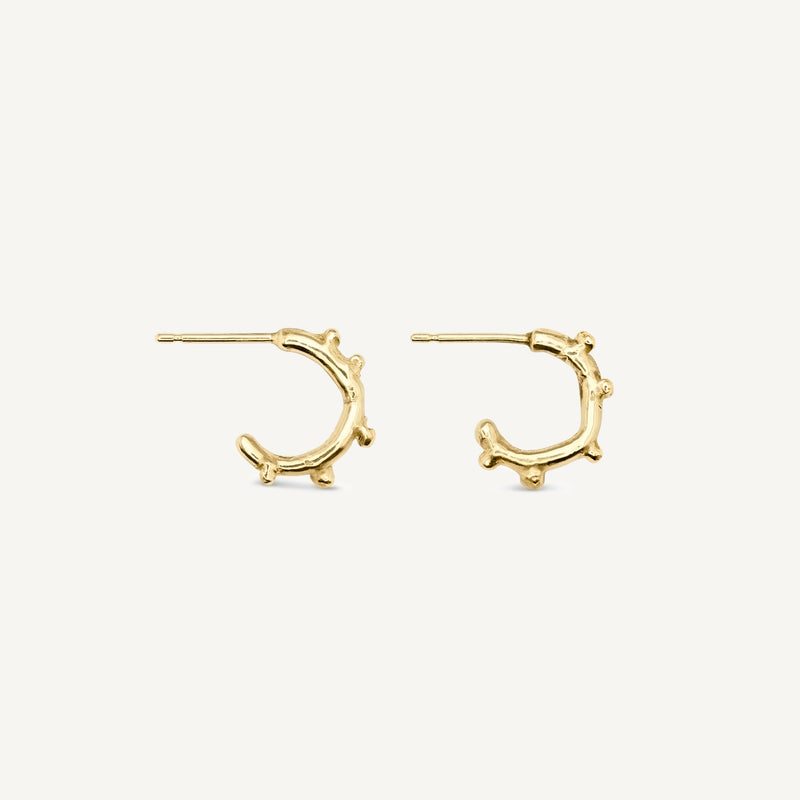 Small textured hoop earrings made in solid 14ct yellow gold. Stacking huggie hoops with unusual texture, these mini hoops are handmade in South London.