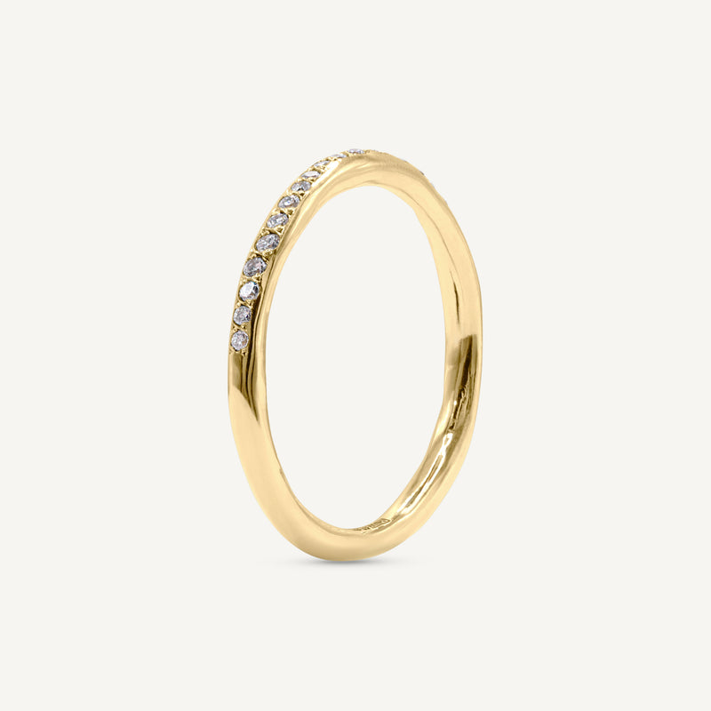A modern and playful slim eternity ring set with a delicate line of diamonds half way around the band. 100% recycled solid 14ct gold and ethically sourced gemstones. Handmade by Robyn in her South London studio.
