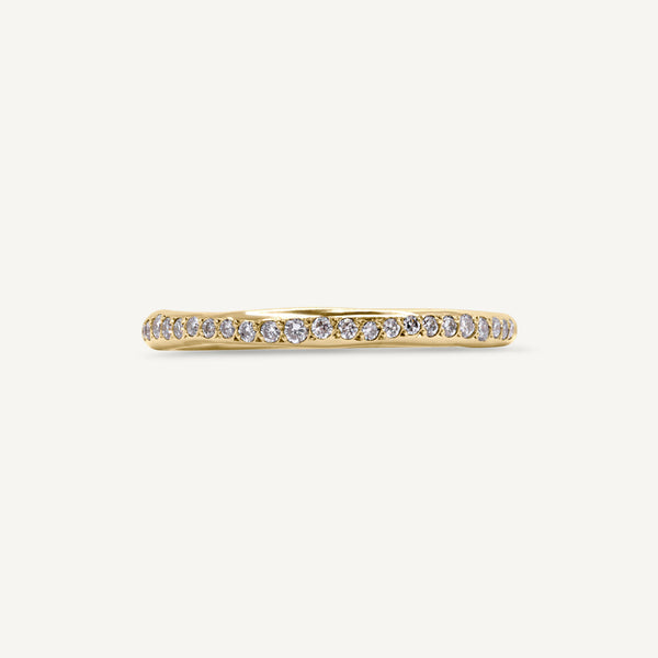 A modern and playful slim eternity ring set with a delicate line of diamonds half way around the band. 100% recycled solid 14ct gold and ethically sourced gemstones. Handmade by Robyn in her South London studio.
