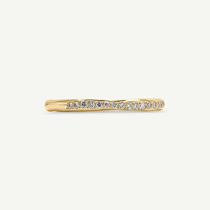 A modern and playful slim eternity ring set with a delicate line of diamonds half way around the band. 100% recycled solid 14ct gold and ethically sourced gemstones. Handmade by South London Jeweller Robyn in her studio.