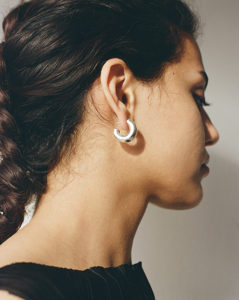 These chunky recycled silver statement hoop earrings with an organic texture are ethically handmade in London by Robyn Smith for Folde Jewellery.
