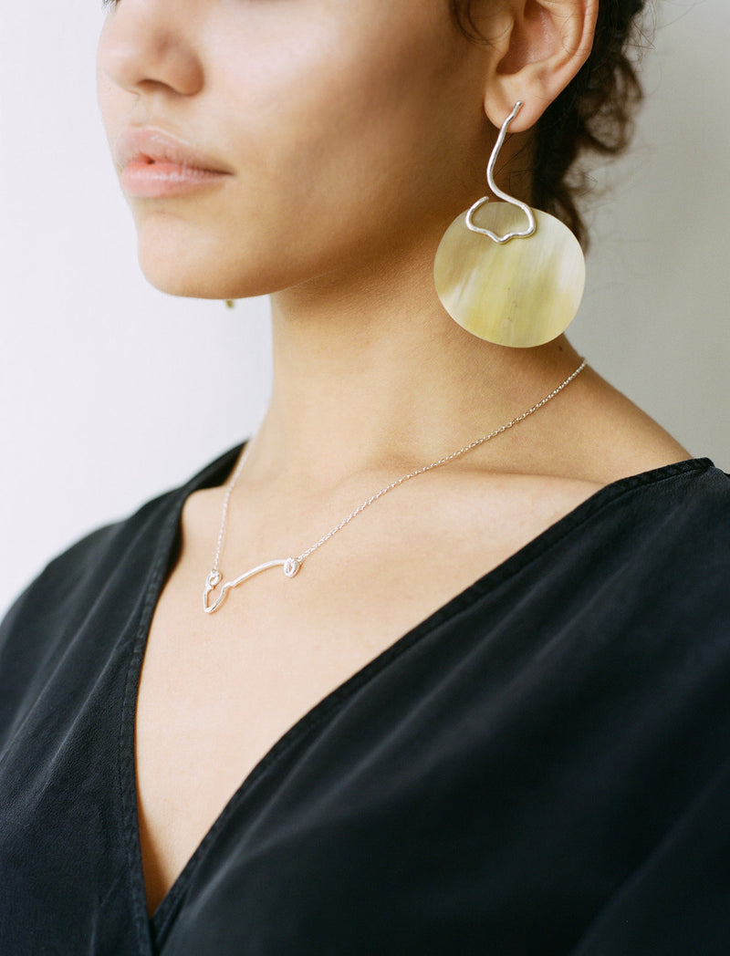 The IDA necklace is a sculptural elegant silver line necklace featuring organic texture ethically handmade in London from recycled silver by Robyn Smith for  Folde Jewellery.